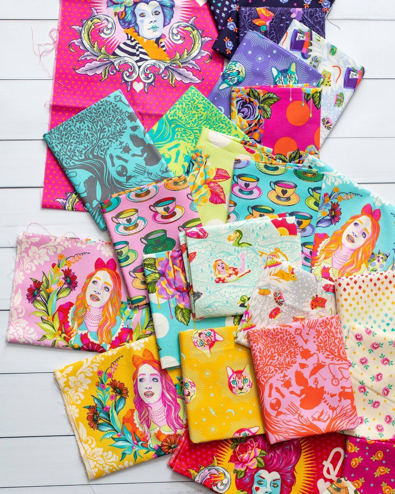 Assorted printed fabric squares in bright colors with character motifs, neatly stacked