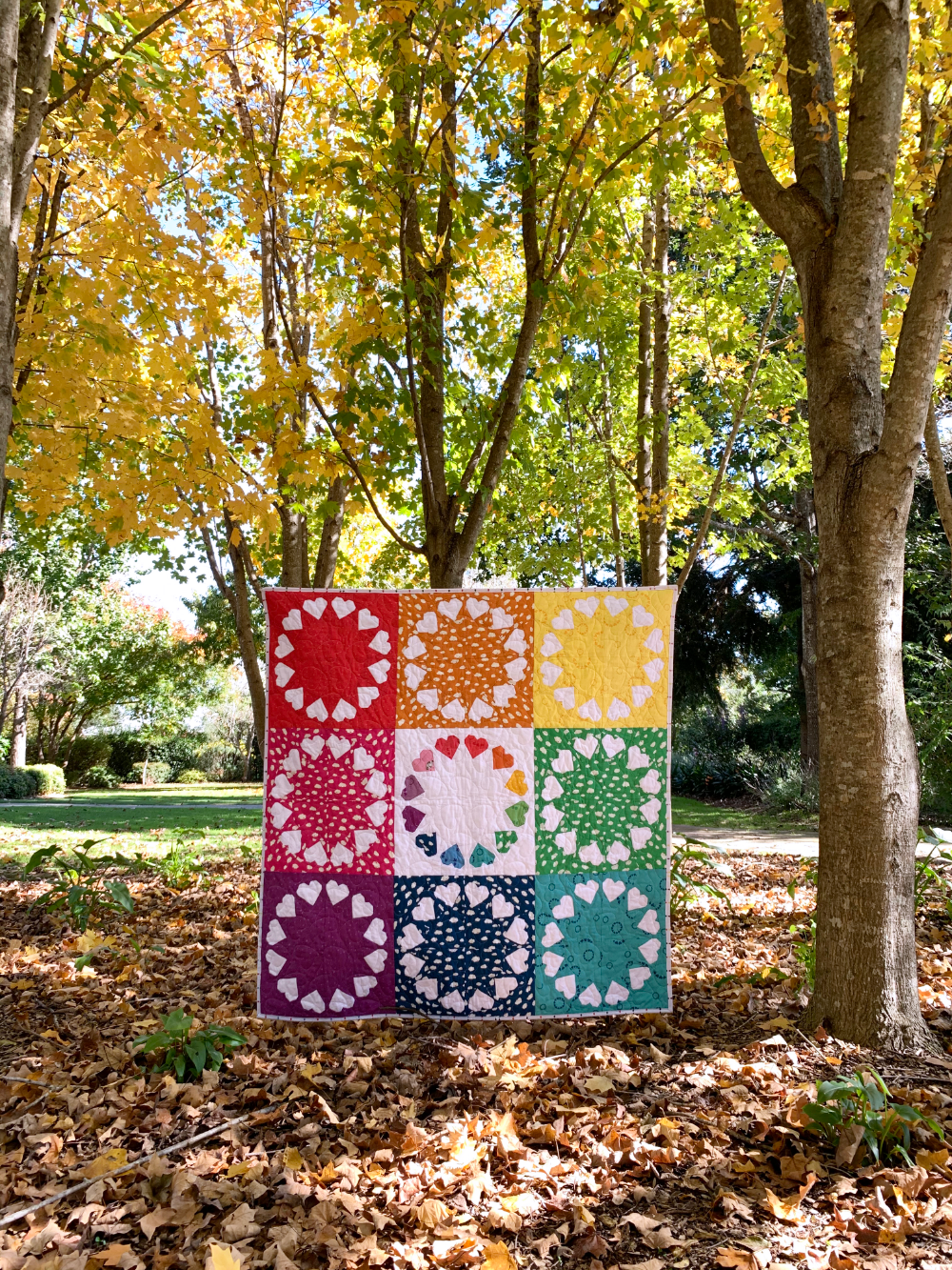 Heart patchwork quilt with bright multicolor squares hanging outdoors