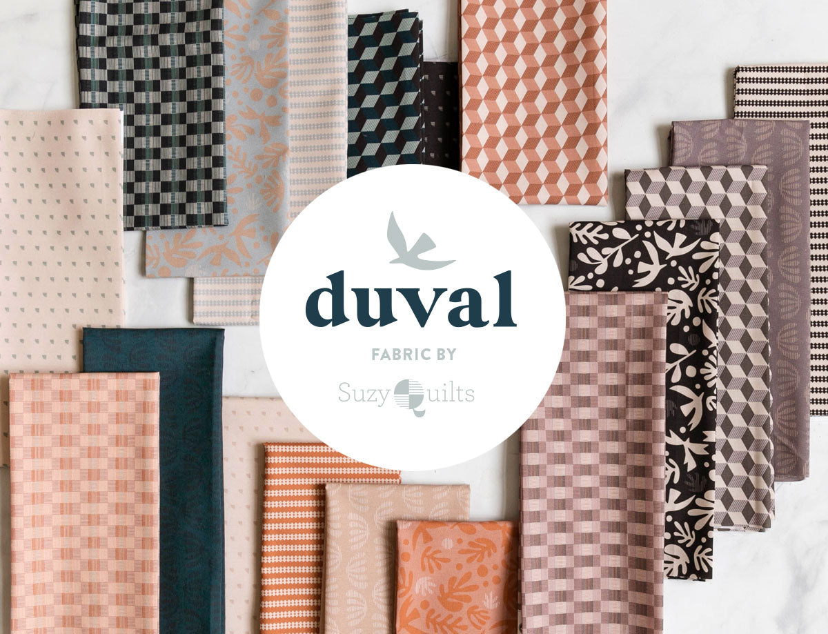 Assorted quilting fabric swatches in geometric prints, including orange, teal, and gray