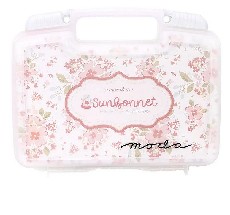 Sunbonnet quilt kit storage bin front with pink floral pattern and logo label
