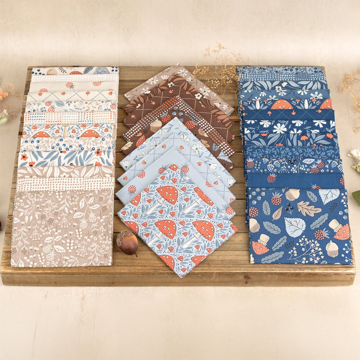 2.5-inch fabric charm squares bundled on a wooden board with woodland and floral patterns