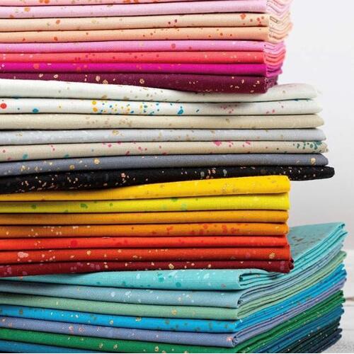 Speckled fat quarter bundle of multicolor fabric stacks with scattered dot pattern