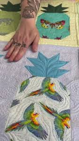 Quilt with bird and leaf applique in blue, white, green, and orange