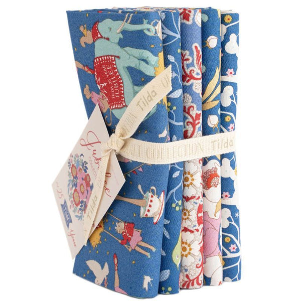 Blue fabric fat quarter bundle with holiday animal motifs, wrapped with ribbon