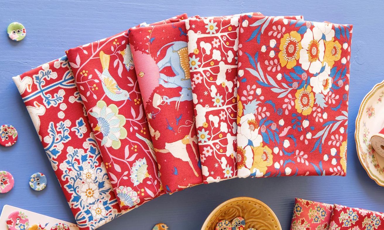 Cotton fat quarter bundle laid flat with red, cream, and blue floral and bird prints