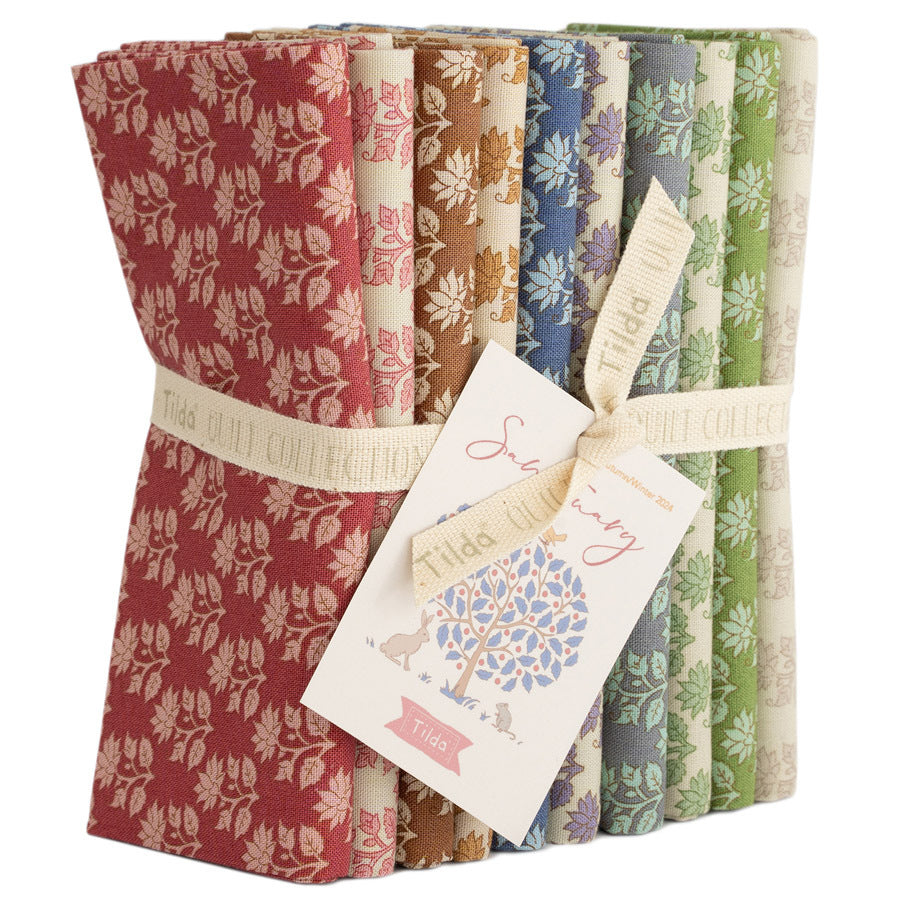 Floral fabric fat quarter bundle in red, tan, blue, and green rolls with gift tag