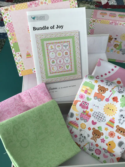 Quilt panel kit with boxed label and stacked pastel fabrics featuring animal prints