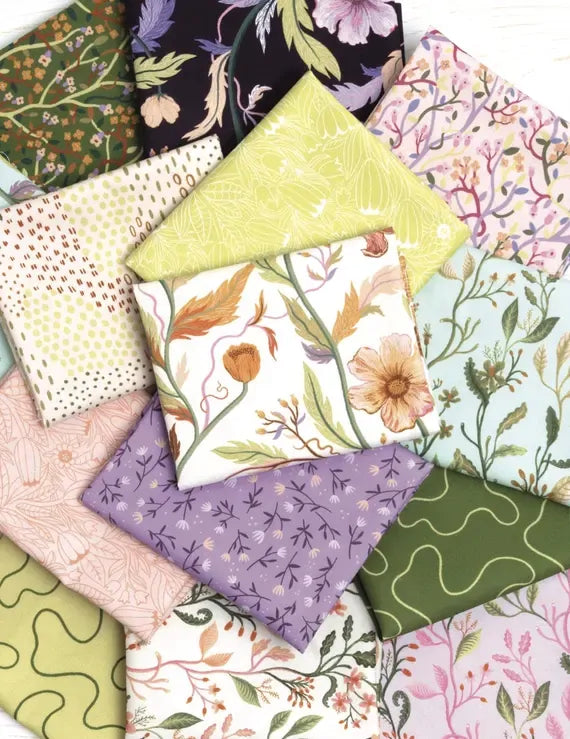 Assorted warm-toned floral and textured fabric squares, folded in a bundle