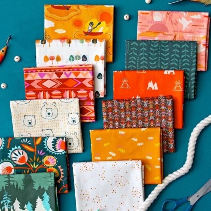Fat quarter bundle of 12 folded fabrics in orange, teal, pink, and green nature prints