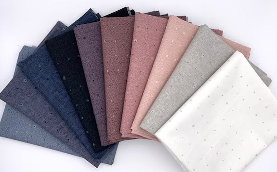 Cotton fat quarter bundle of assorted blue, gray, pink, and cream speckled prints