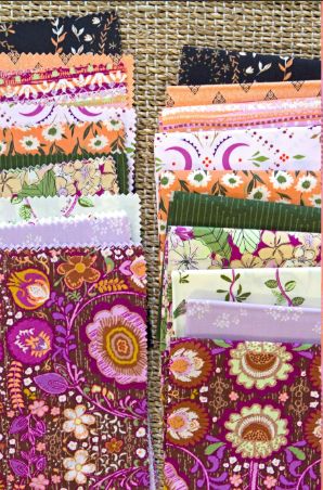 Assorted 10-inch fabric squares stacked, bright floral and paisley designs