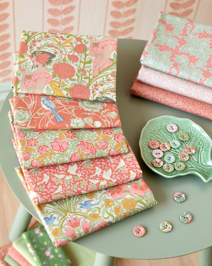 Assorted coral, green, and cream floral bird fat quarters stacked and folded