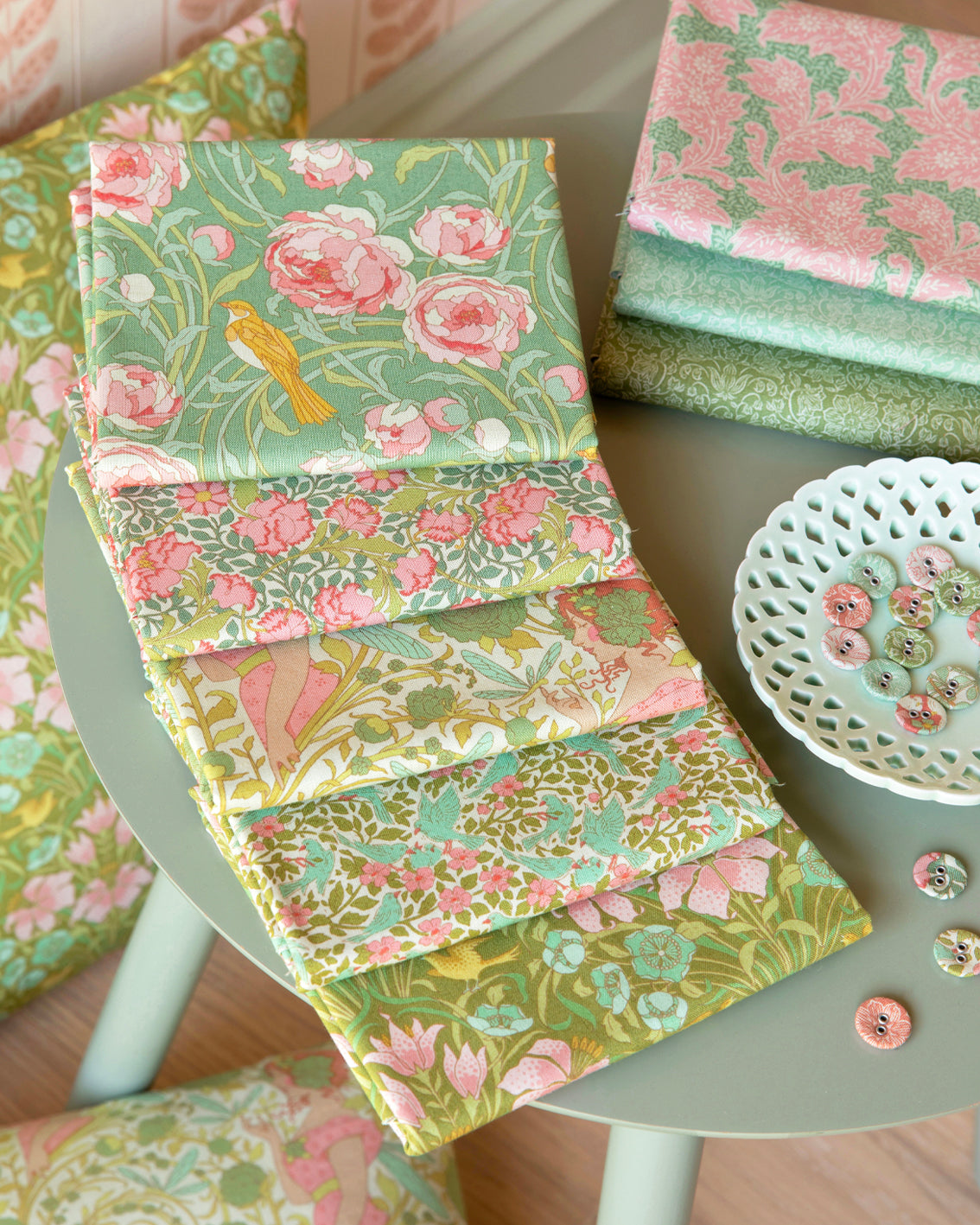 Fat quarters bundle showing folded floral fabrics in green and pink, layered stacks