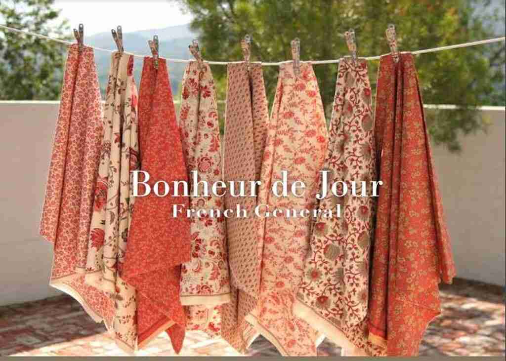 Printed fabric bundle on a clothesline, red and cream floral quilt blocks