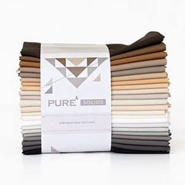 Assorted solid fabric fat quarters bundle, neatly stacked in warm and neutral tones