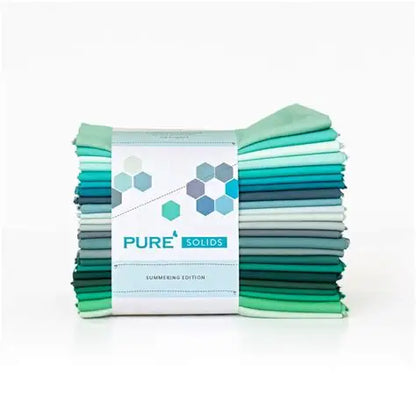 Neatly folded solid fabric fat quarter bundle with 'PURE SOLIDS' label in teal