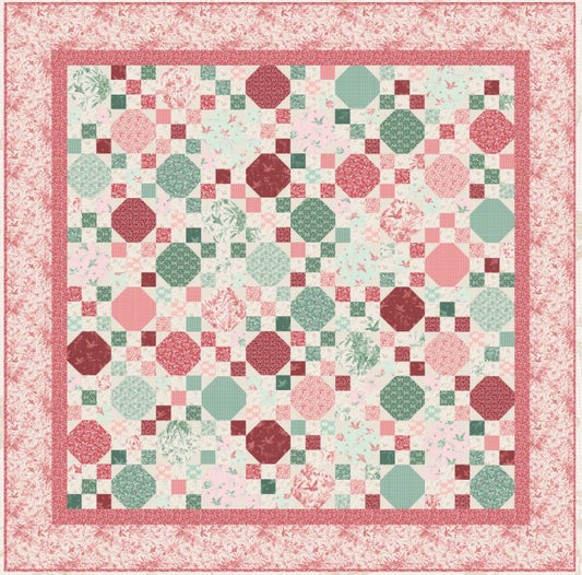 Patchwork quilt pattern with pink, red, and green geometric blocks in a bordered layout