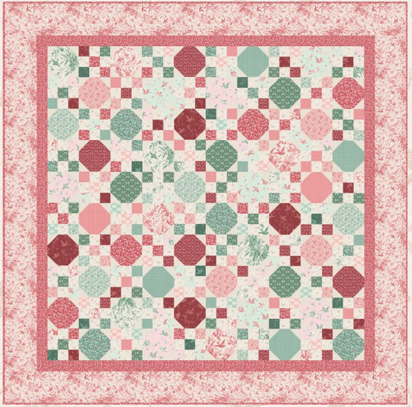 Patchwork quilt pattern with pink, red, and green geometric blocks in a bordered layout
