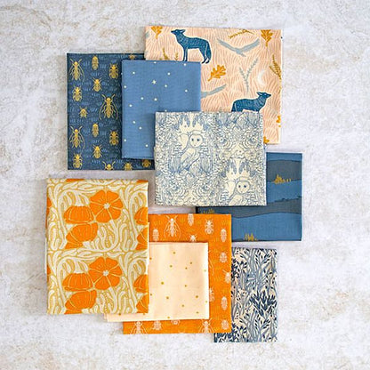 Assorted fabric squares, layered with blue and orange animal and star patterns