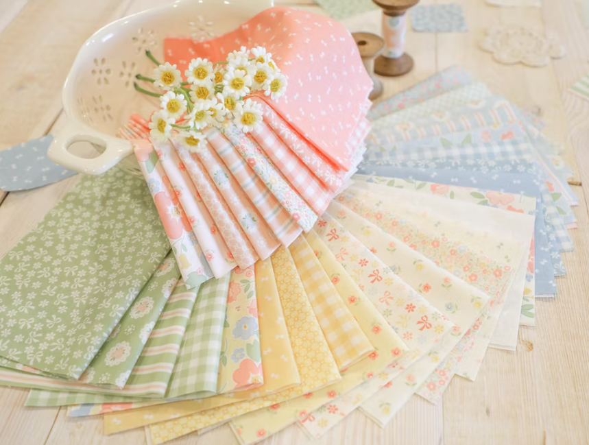 Fabric fat eighth bundle with pastel florals and stripes, fanned on tabletop