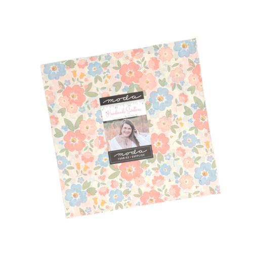 Pastel floral 10-inch fabric layer cake pack with pre-cut squares in soft creams, pinks, and blues.