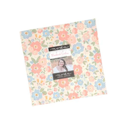 Pastel floral 10-inch fabric layer cake pack with pre-cut squares in soft creams, pinks, and blues.