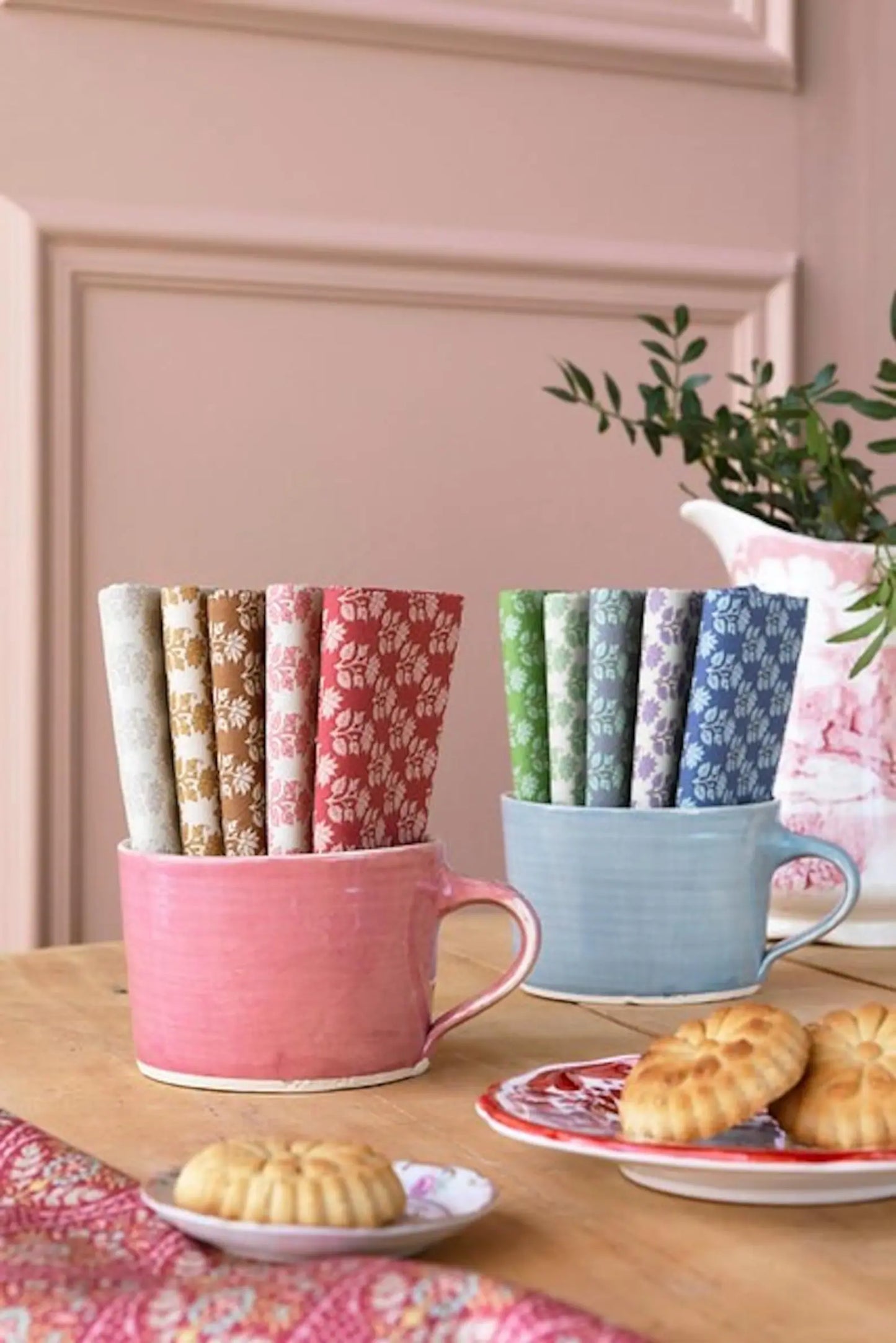 Floral cotton fat quarters in pink, cream, blue, and green arranged in mugs