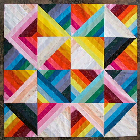 Geometric patchwork quilt top with rainbow pinwheel and chevron blocks