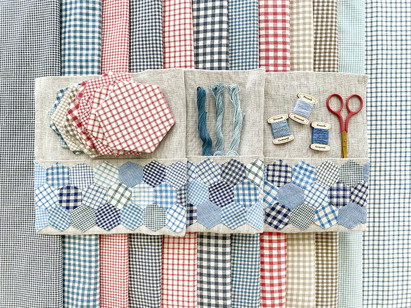 Collection of fabric swatches and sewing tools on a checkered background