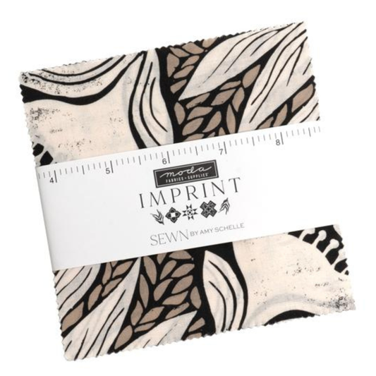 A charm square pack wrapped with a white paper band labeled 'imprint' and 'SEWN BY AMY SCHELLE', featuring a black, beige, and off-white abstract botanical pattern.