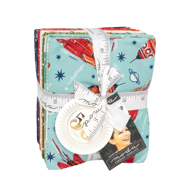 A bundle of fabric fat quarters wrapped with a white ribbon, featuring a space-themed print with red rockets, blue stars, and a light blue background. A round white tag and a black 'Made by Martha' brand tag are attached.