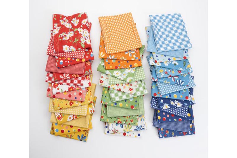 Collection of colorful fabric squares with various patterns on a white merican Jane Story Time Moda Fabrics with colourful retro patchwork fabrics inspired by classic storybooks and vintage childhood themes.background