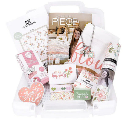 Quilt kit storage bin filled with patchwork fabric prints and stitched card labels