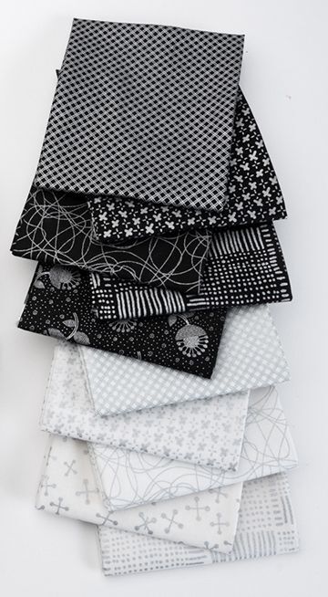Stack of metallic silver, black and white patterned fabric squares on a white background