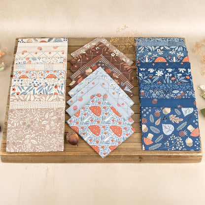 2.5-inch fabric charm squares bundled on a wooden board with woodland and floral patterns