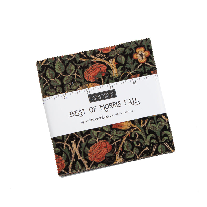 Moda charm squares bundle on dark fabric with red-orange flowers and green leaves.