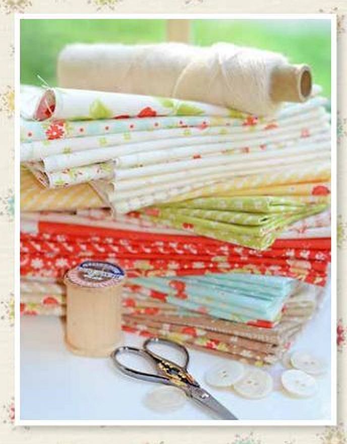 Stacked floral fabric bundles in soft reds, greens, and yellows, with charm squares