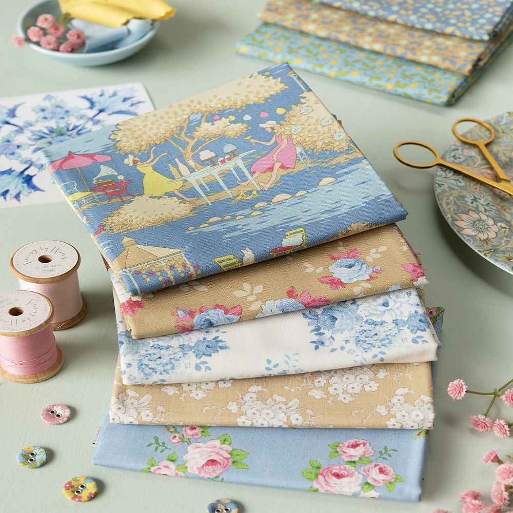 Floral fabric fat quarter stack with blue, beige, and pink patterns