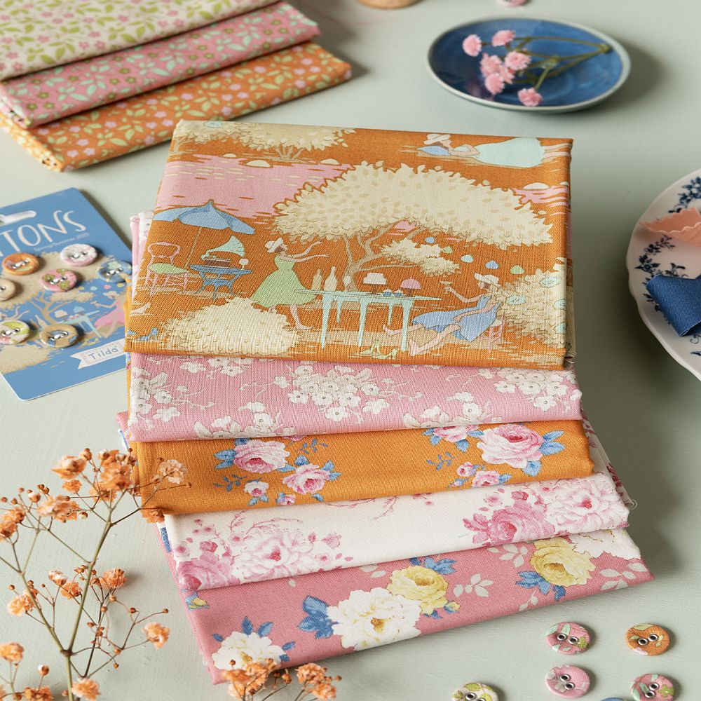 Stacked floral fat quarter fabrics in orange, pink, and white with mixed prints